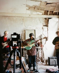 a group of people playing guitars in an abandoned room